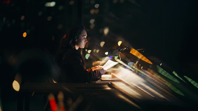 Overloaded businesswoman doing paperwork at dark workplace. Lady reading papers
