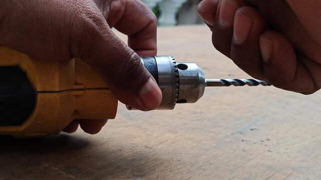 Hand tightening and securing a drill bit into an electric drill chuck