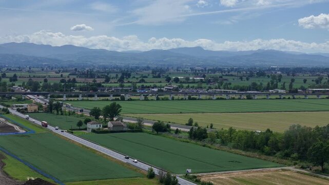 Po Valley farmland extends between the A1 Autostrada del Sole, the Milan&ndash;Bologna railway and SS9 Via Emilia in Emilia-Romagna, Italy, beneath the Northern Apennines, drone descent aerial shot.