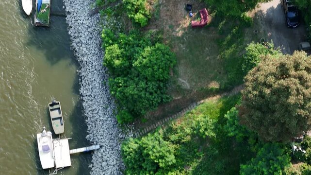 Small boats moored along the Po River beside a riprap embankment near Castelvetro Piacentino, Piacenza, Emilia-Romagna, Italy, exposing exceptionally low water levels during the June 2026 heatwave