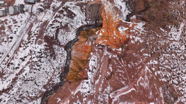 Puente del Inca reveals mineral rich geothermal formations, travertine deposits and a mountain stream in Mendoza, Argentina, showcasing distinctive geological processes, top down drone forward flight