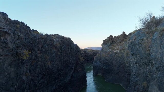 Aerial footage capturing the rugged volcanic canyon in La Payunia Reserve, Mendoza, Argentina at sunrise.