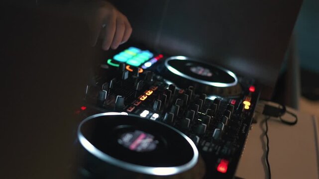 A DJ skillfully mixes tracks on digital turntables, creating dynamic sounds in a dimly lit setting.