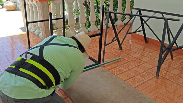 Person measuring an mdf board with a tape measure to fit an iron table frame