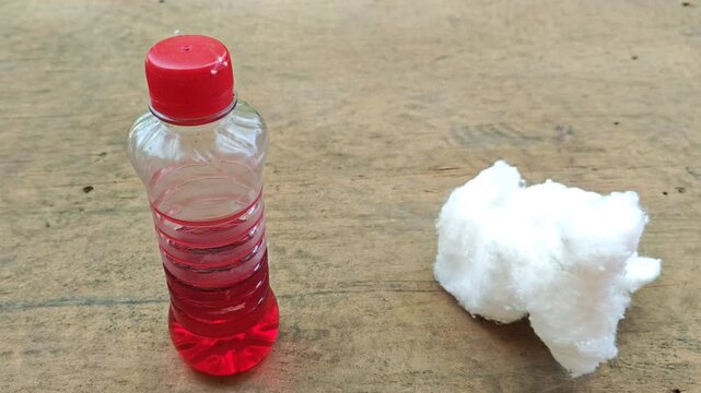 Hands showing a bottle of protective oil and cotton before treating wood