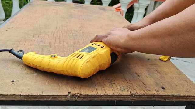 Hand inserting a metal drill bit into an electric cordless drill