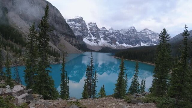 Clouds drift around the Valley of the Ten Peaks in a time lapse over Moraine Lake&rsquo;s turquoise water and dark conifer slopes.