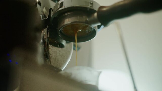 4K Espresso pouring from coffee machine at cafe,Brewing the espresso coffee from the machine warm tone.