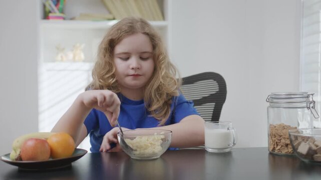 Child eating pasta at home. Child enjoying warm pasta meal. Child having healthy food indoors. Child sitting at table with pasta. Hungry kid eat paste for breakfast.