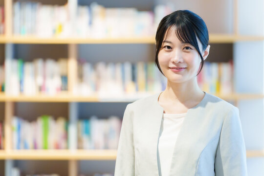 本棚の前に立つ女性　作家　小説家　エッセイスト