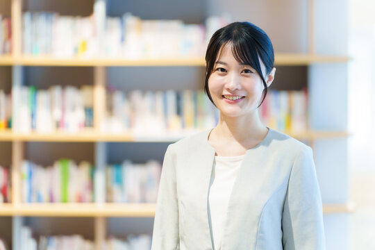 本棚の前に立つ女性　作家　小説家　エッセイスト
