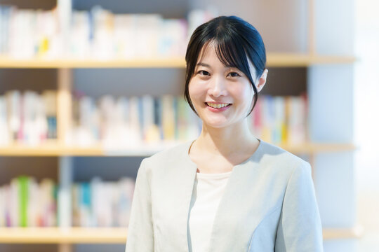 本棚の前に立つ女性　作家　小説家　エッセイスト