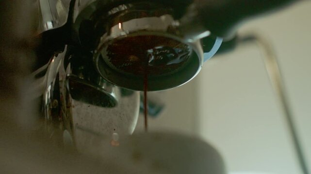 4K Espresso pouring from coffee machine at cafe,Brewing the espresso coffee from the machine warm tone.