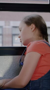 Vertical crying sad girl on school bus
