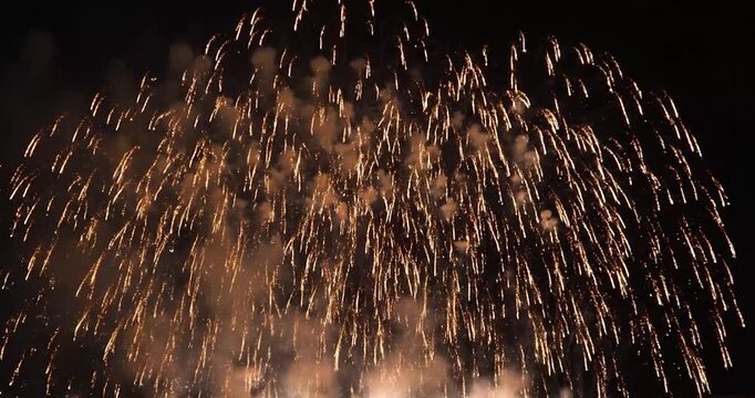 Bright golden fireworks exploding in the night sky during celebration