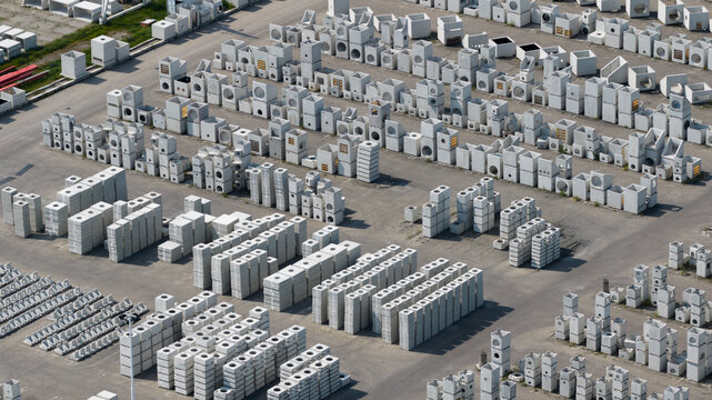 Aerial view of rows of precast concrete drainage elements and construction materials neatly arranged in a manufacturing yard in Oosterhout, North Brabant, Netherlands.