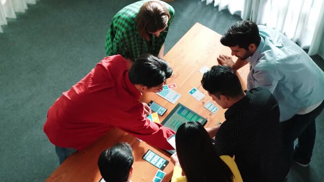 Top view of diverse business people discussing idea and designing system while using tablet with Ux, Ui design display on screen. Multicultural working together and planning strategy. Convocation.