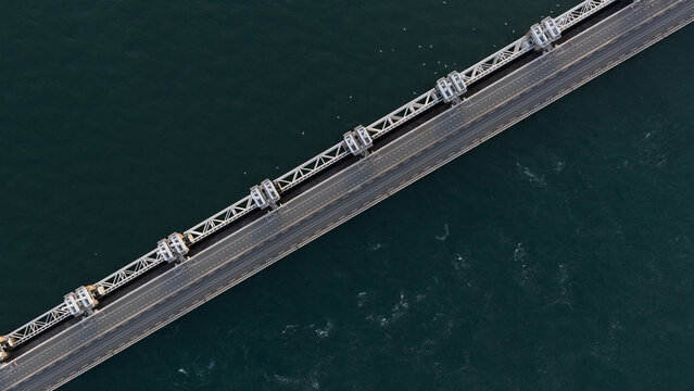Aerial view of the Eastern Scheldt Storm Surge Barrier showing the road bridge structure spanning the dark water in Vrouwenpolder, Zeeland, Netherlands.