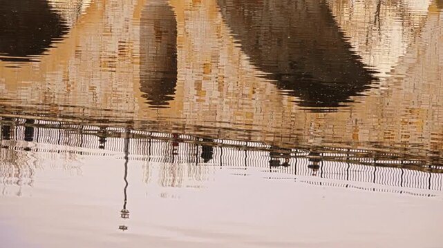Masonry Pointed arch Stone bridge (Puente de Piedra) across the river Duero in Zamora, Castile-Leon, Spain. Reflection in the water. Autumn nature. Pedestrians walking on the bridge.