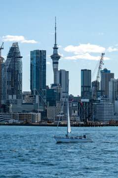 Sailboat crossing the Waitemata Harbour below Auckland's skyline, amid the city's ongoing construction boom, Auckland, New Zealand, November 2025.