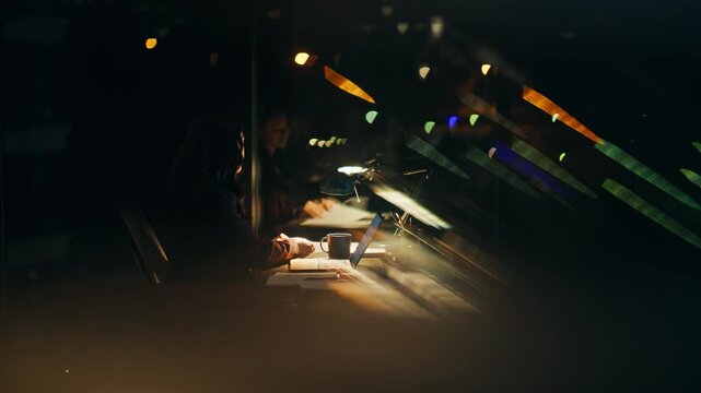 Night employee doing paperwork working laptop startup at dark corporate office
