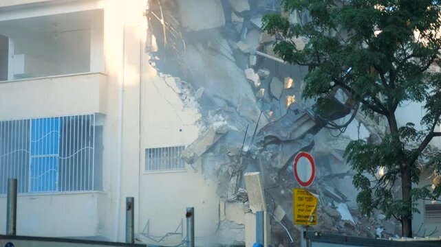 Close details follow compactor crane of building demolition with excavator during urban redevelopment project
