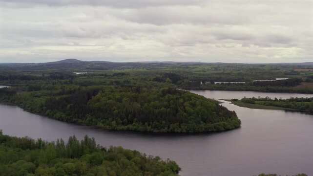Dynamic aerial shot of Lough Oughter on quiet evening with peaceful landscape. County Cavan