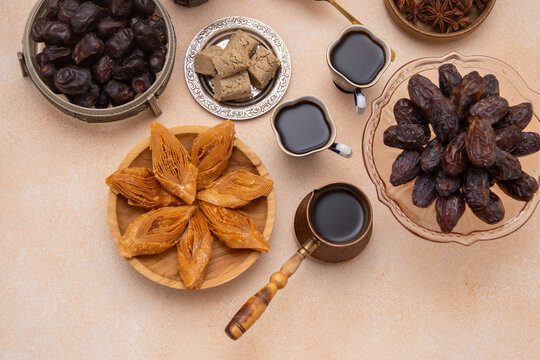 Oriental sweets and coffee on the table. Baklava, halva, Dates fruit for dessert. Food and drink.