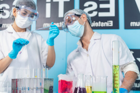 Scientist man woman working together team partner look into Microscope research in science laboratory. Two Asian scientist use microbiology microscope chemistry lab equipment. Biochemistry researcher