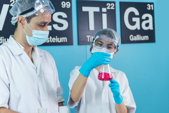 Scientist man woman working together team partner look into Microscope research in science laboratory. Two Asian scientist use microbiology microscope chemistry lab equipment. Biochemistry researcher