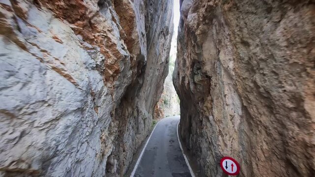 Narrow road through deep rocky gorge in Sa Calobra Mallorca Spain