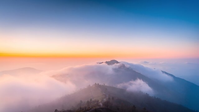 Breathtaking mountain landscape with sunrise and rolling clouds