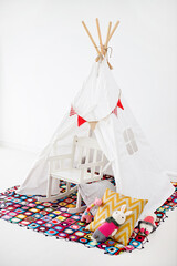 Cozy kids nursery playroom setup with teepee tent and crochet rug © ltyuan