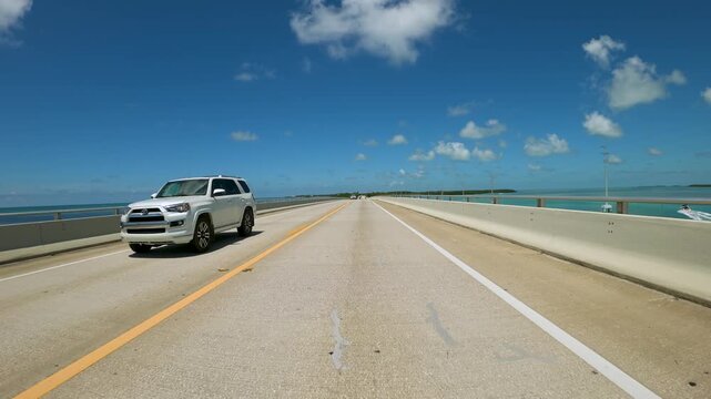 Driving a car on Florida Keys Highway Over Water ,  along a two lane highway built over a body of water in  Florida