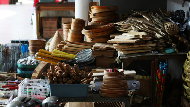 Traditional wooden kitchenware and woven bamboo utensils at a market stall