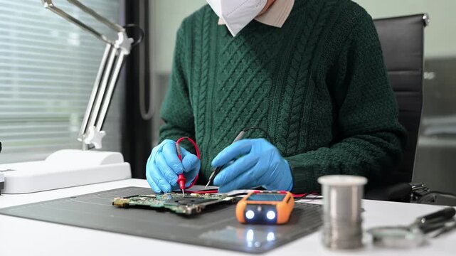 Closeup of expert soldering a green PCB board using precision tools. Ideal for electronics, circuit repair, engineering, tech