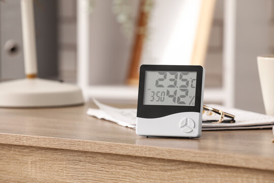 Digital thermometer and hygrometer on wooden desk
