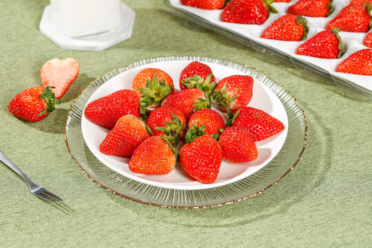 Fresh Cut Strawberries Still Life Indoor Studio Photography with Glass Plate and Green Background