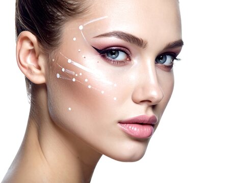 A woman's face with a white dotted facial diagram on her cheek