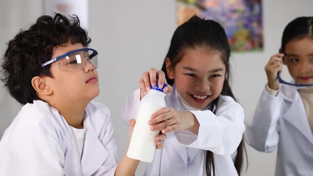 Asian Children in Lab Coats Conducting Science Experiment with Plastic Bottle