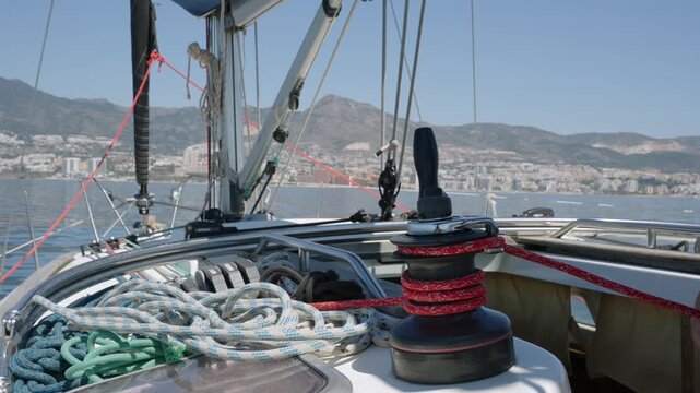 Sailor's hands operating a winch on a sailboat