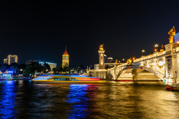 Naklejka premium Historic Bridge and River at Night with Illuminated Monuments
