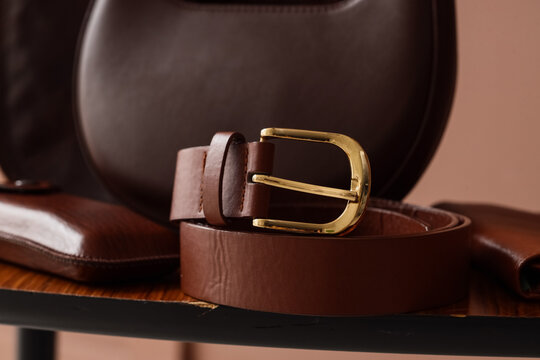 brown leather belt with gold buckle on chair
