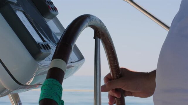 Captain sailing boat with hands on helm