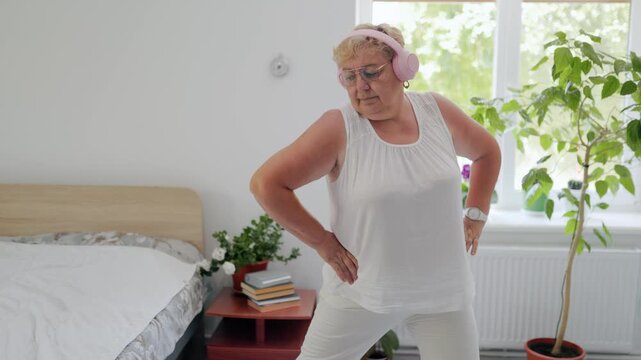 Overweight mature female performing side lunges in her home bedroom fitness at home