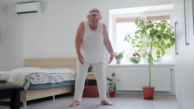 Older elderly lady doing deep breathing chest expansions at home fitness at home