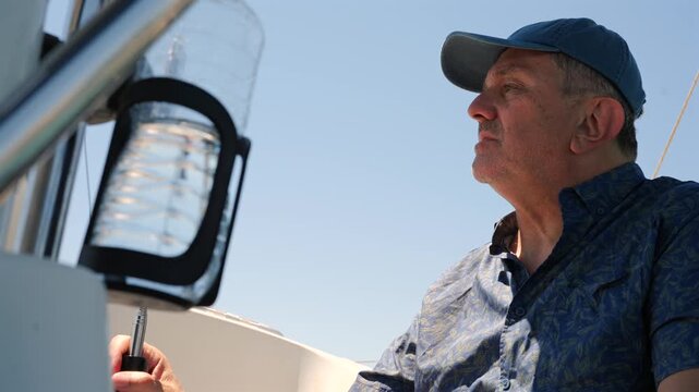 Mature captain steering sailboat at sea
