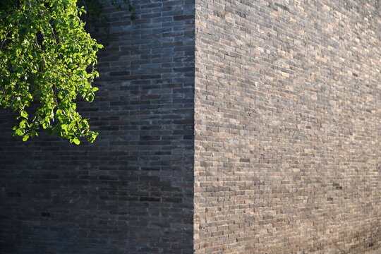 A corner of an ancient city wall stands divided&mdash;one side bathed in warm sunlight, the other cloaked in cool shadow, embodying time&rsquo;s quiet duality.