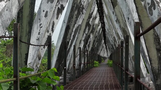 Weathered geometric concrete bridge interior with symmetrical pedestrian walkway