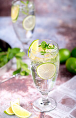 Fototapeta premium Refreshing lime and lemon drink with mint and ice in tall glasses